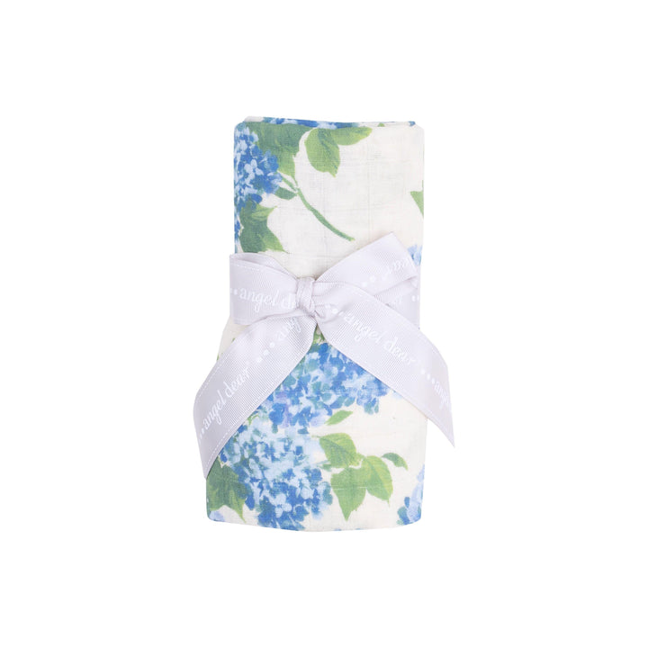 baby swaddle rolled and tied with a ribbon, this is how it is packaged. swaddle has hydrengeas on it in the shade of blue. 
