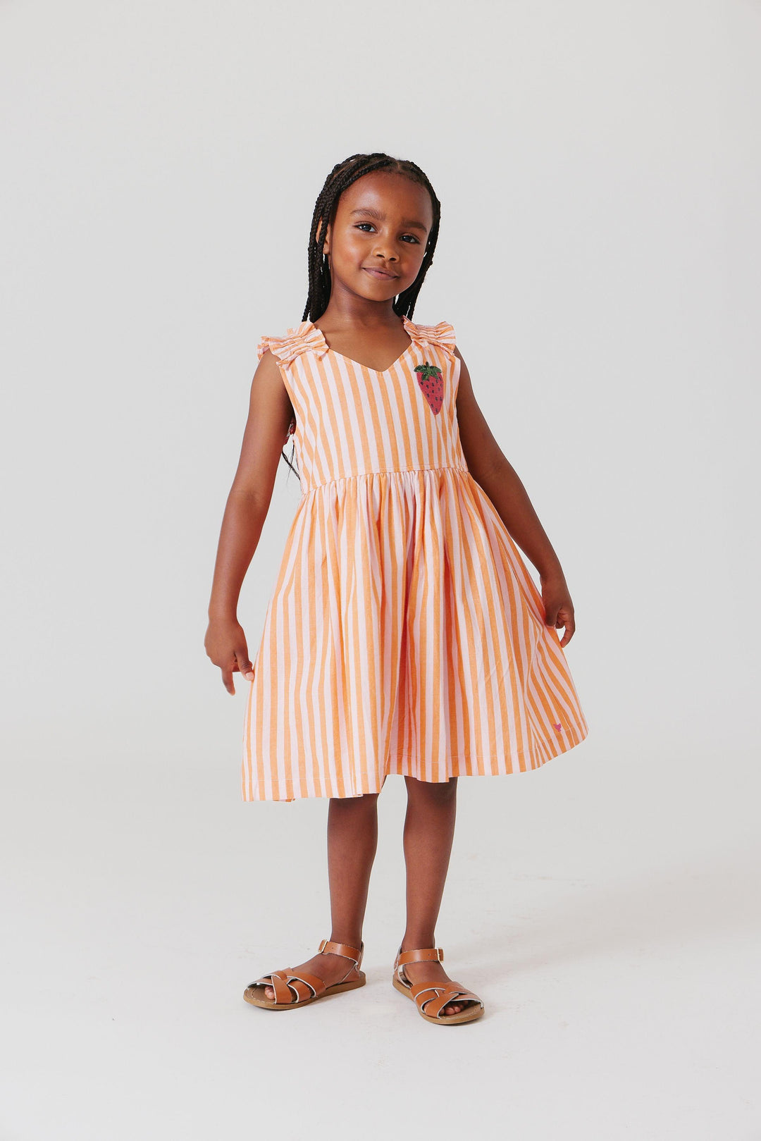 little girl modeling the dress while holding the skirt to show mobility in the dress. 