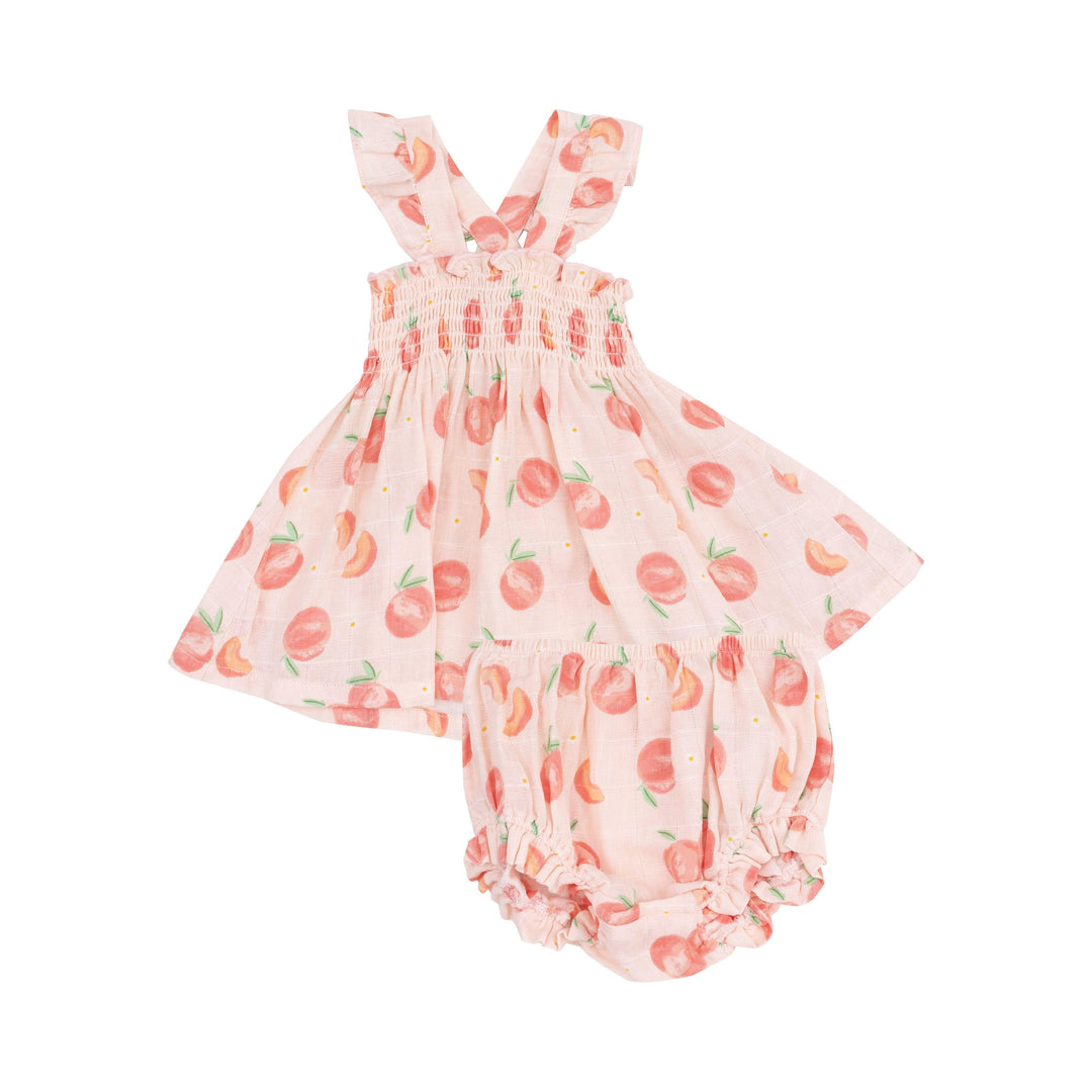 smocked top baby girl dress with peaches and peach halves on the dress. the dress is a pink/peach color. 