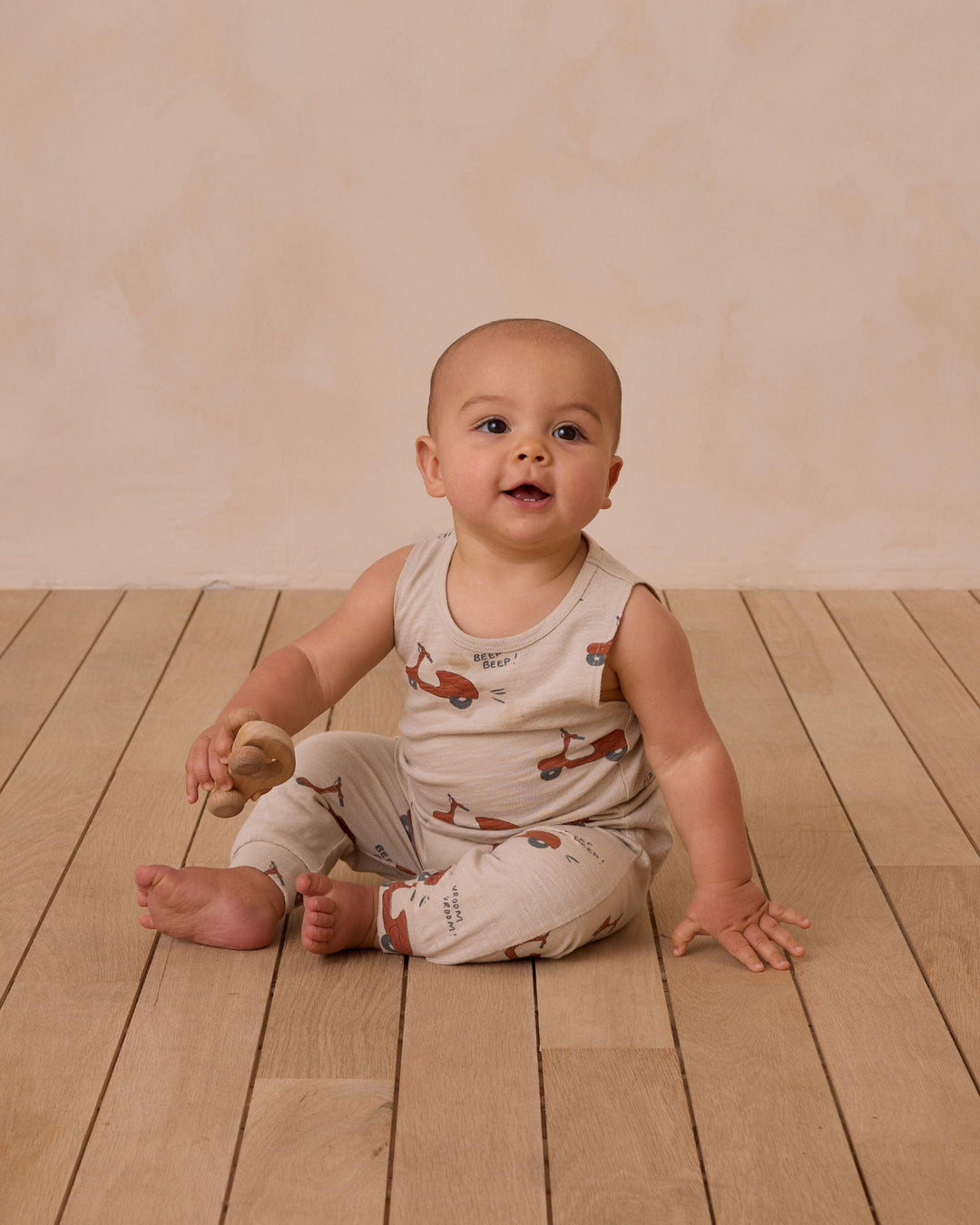 baby sitting on the floor wearing the moped 2 piece set 