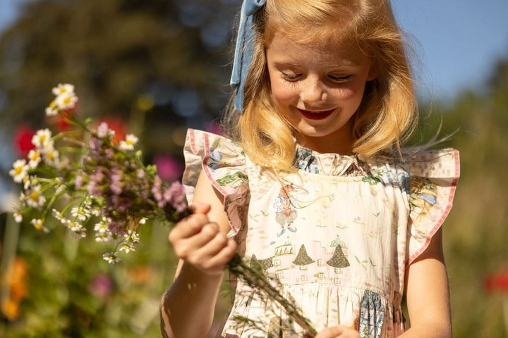Young girl holding a bouquet of flowers in a garden setting