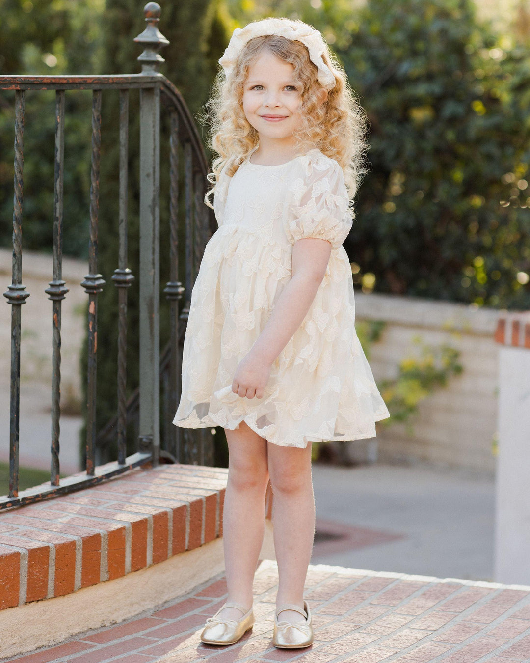 picture of little girl modeling the luna dress with sheer butterfly overlay. the dress hits above the knee. 