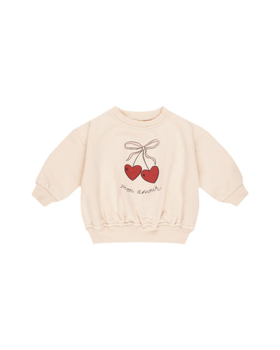 beige sweatshirt with cherries on the sweatshirt with a bow on top