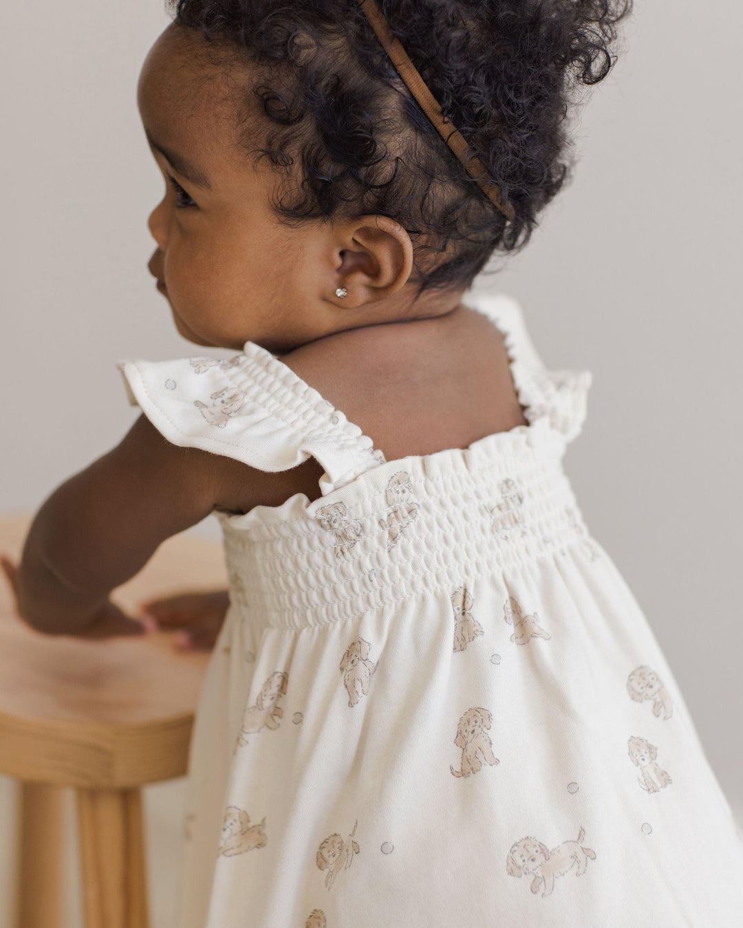 beige dress with smocking on the top and the sleeves. sleeveless dress with tiny brown puppies all over it. 