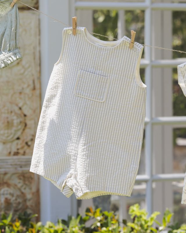 Striped baby romper hanging on a clothesline with a blurred background