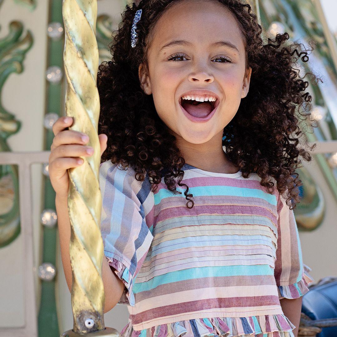 this picture shows the muted pastel stripes with a close up of the pleats on the front center of the dress 
