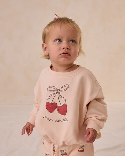 little girl modeling the sweatsuit with the cherries on the pants and sweatshirt