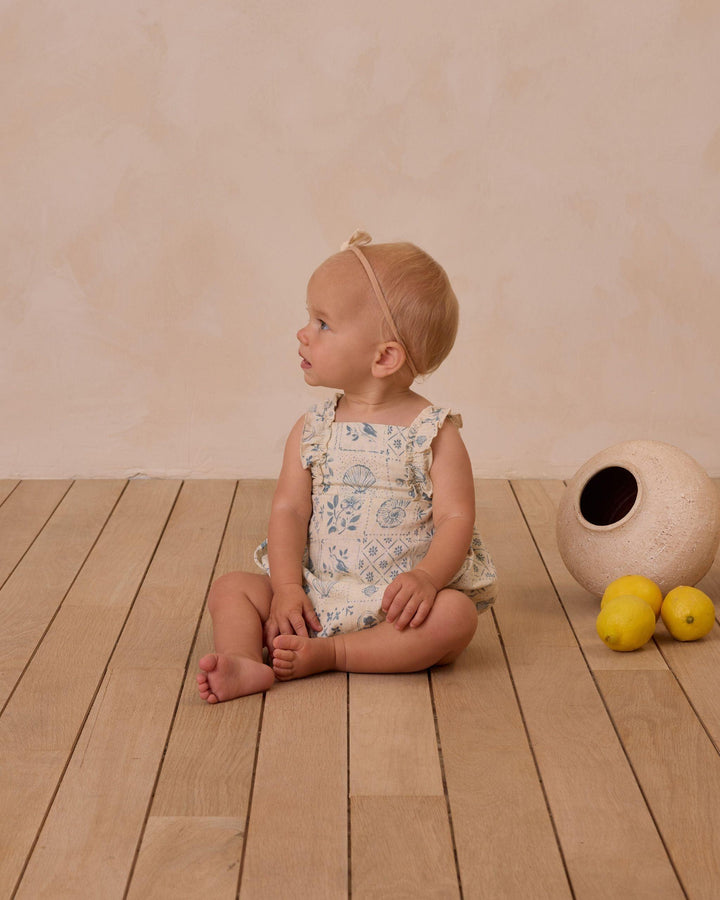 baby modeling the chiara romper in tile print. 