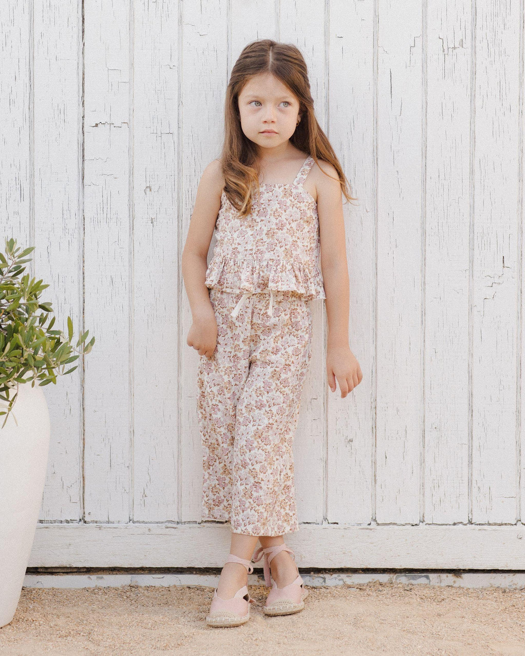 young girl modeling the wildflower pant set, the pants hit above the ankle and the top comes to below her waistline. 