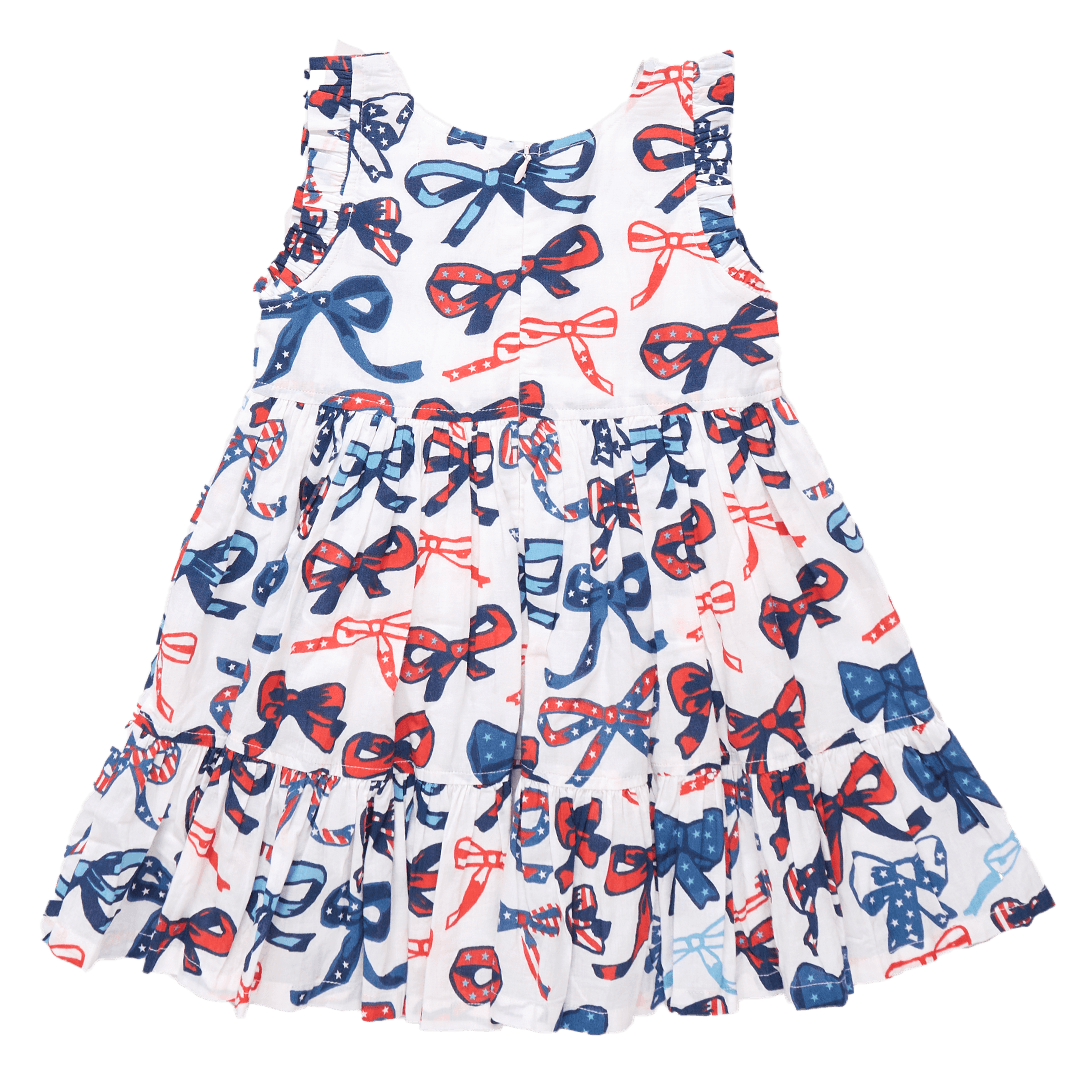 back of dress with hidden zipper and tiered ruffles. sleeveless dress with bows that has red, white and blue stripes and stars in the bows. 