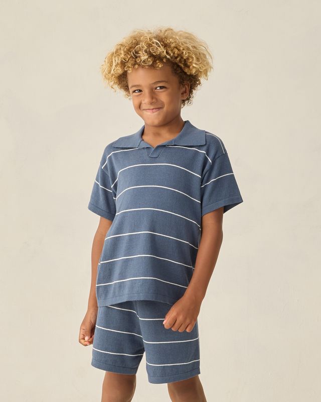 child wearing a blue striped polo shirt and matching shorts 