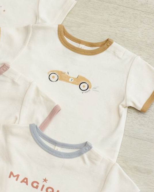 Children's clothing with cartoon designs and text on a neutral background