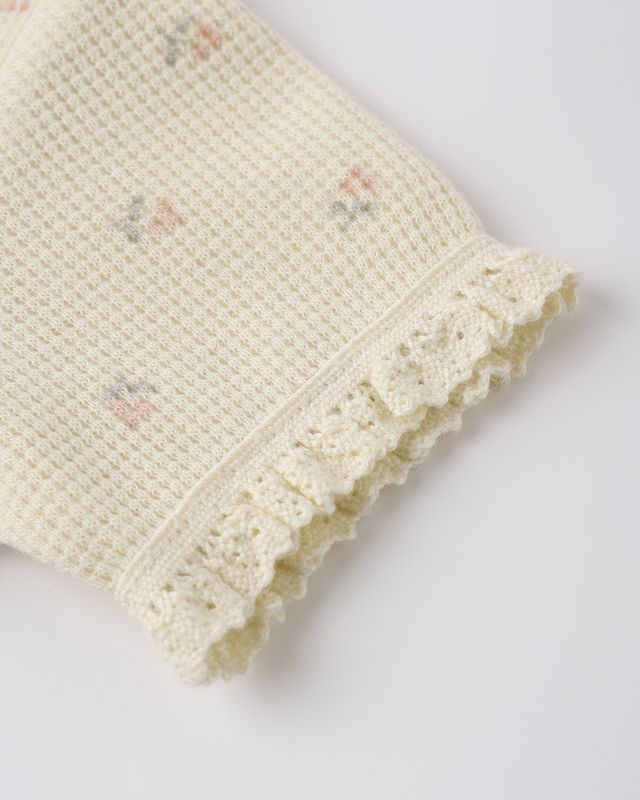 Cream-colored  waffle top with small roses on the fabric. close up od the detail. 