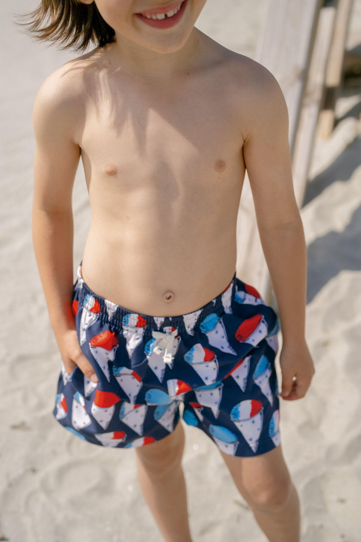 close up of the print and the style swim suit on a little boy. you can see the snow cones in the natural light. 