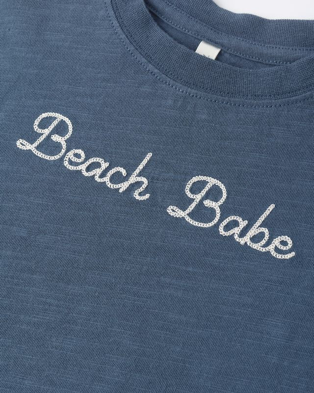 'Beach Babe' embroidered across the chest in navy color. 