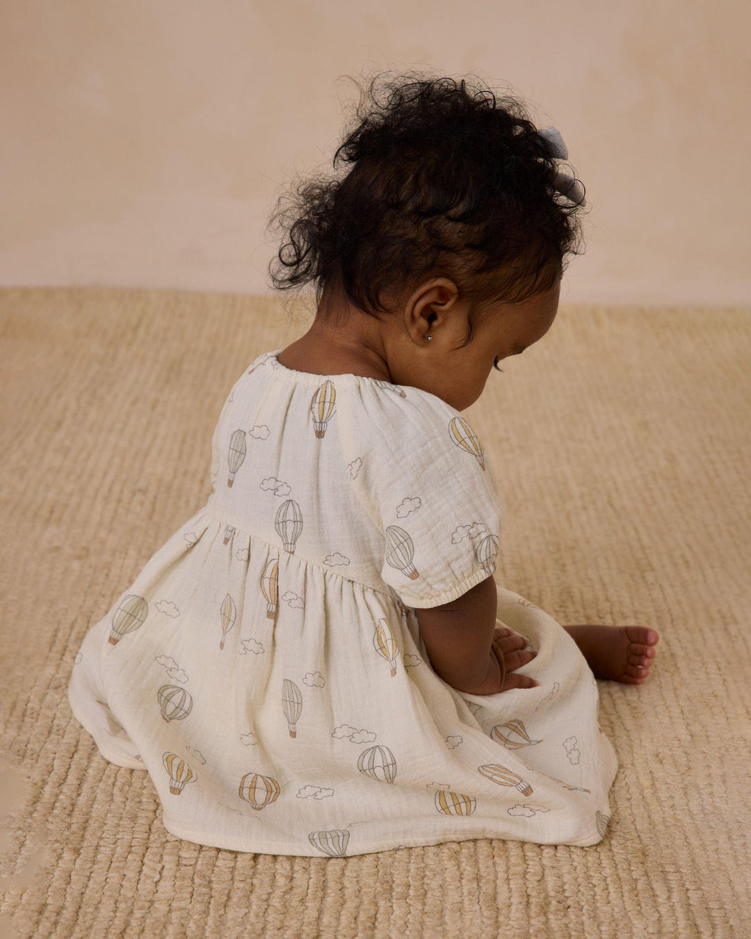 another angle for the baby wearing this dress. you can see the hot air balloon design better from this angle. all different color hot air balloons. 