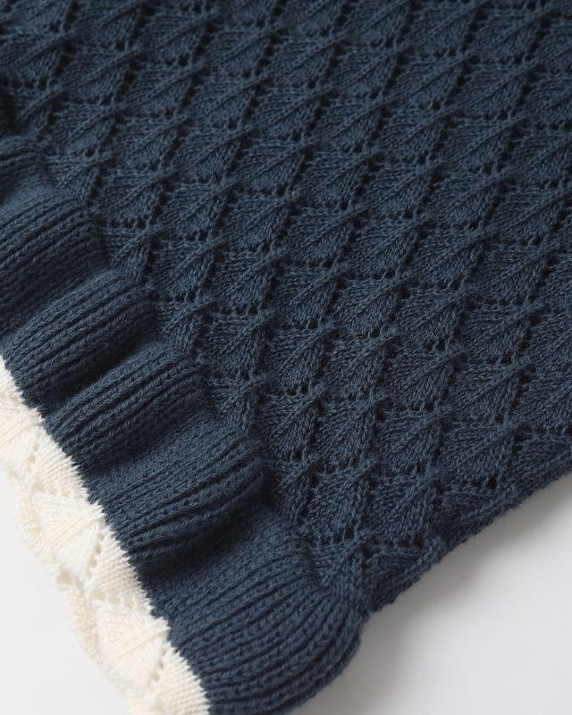 Close-up of a blue knitted with a top white border on a white background