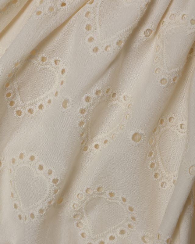 Close-up of beige fabric with eyelet lace-like pattern