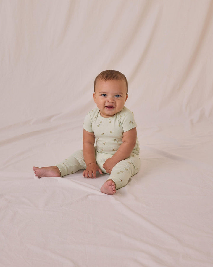 baby sitting in the ribbed mint set with tiny apples all over it. 