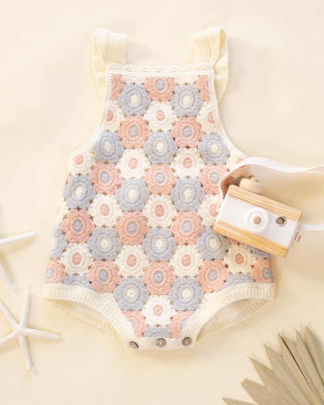 Baby romper with floral pattern on a beige background