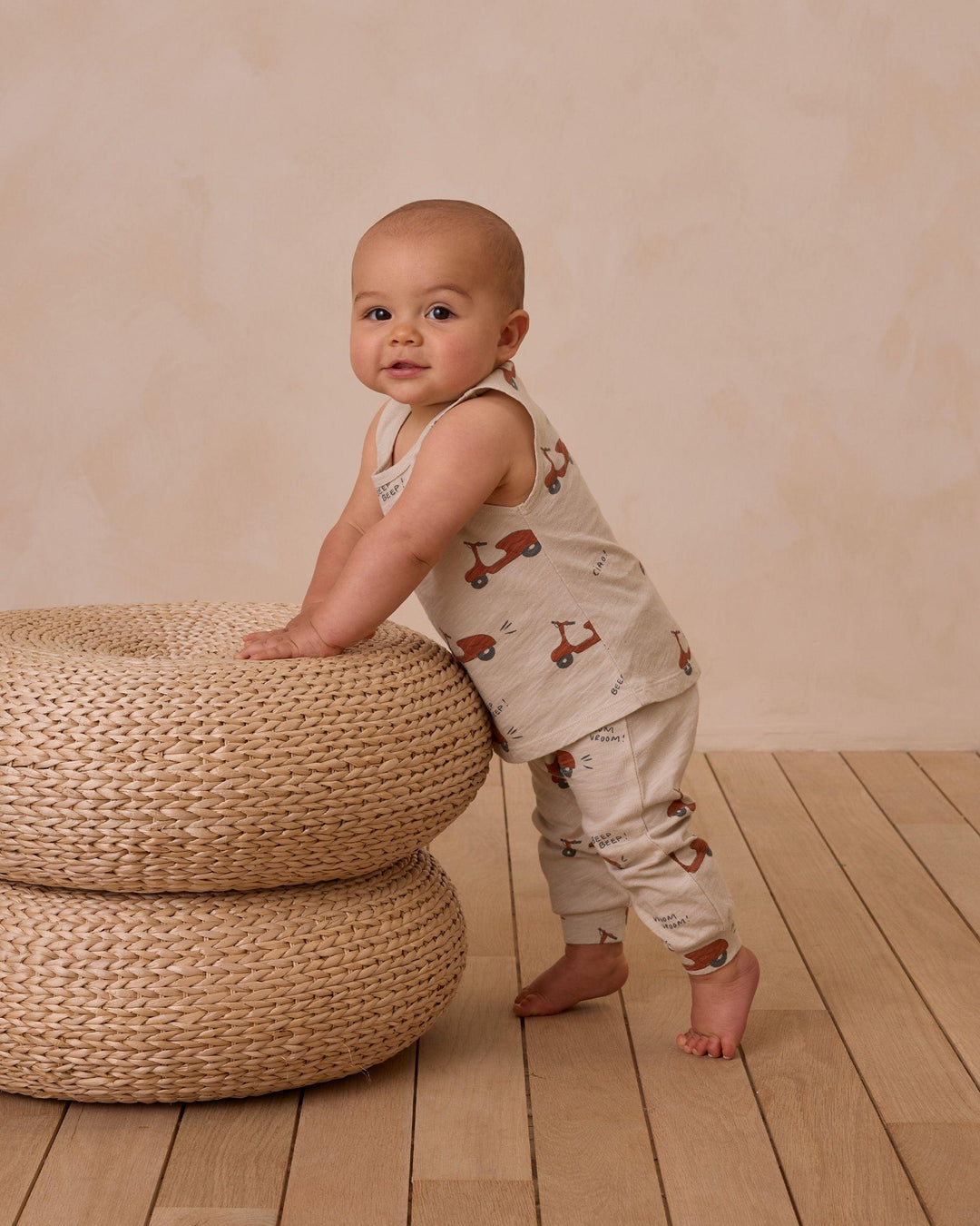 baby modeling the moped tank and slouch set standing up by the ottoman with the top hitting below the waist. 