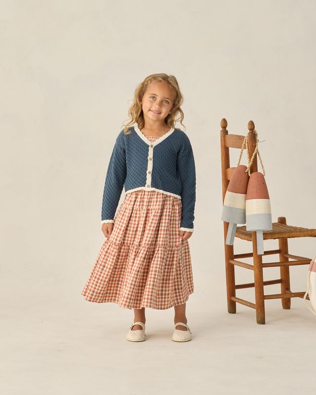 navy cardigan with white scallop trim on a little girl 