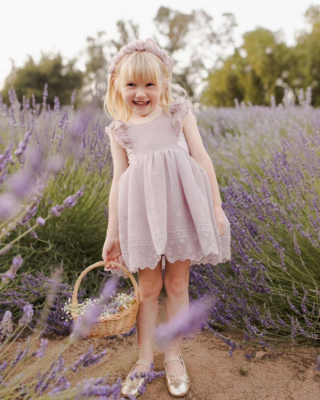 little girl wearing the lavender pinafore in the lavender fields. 