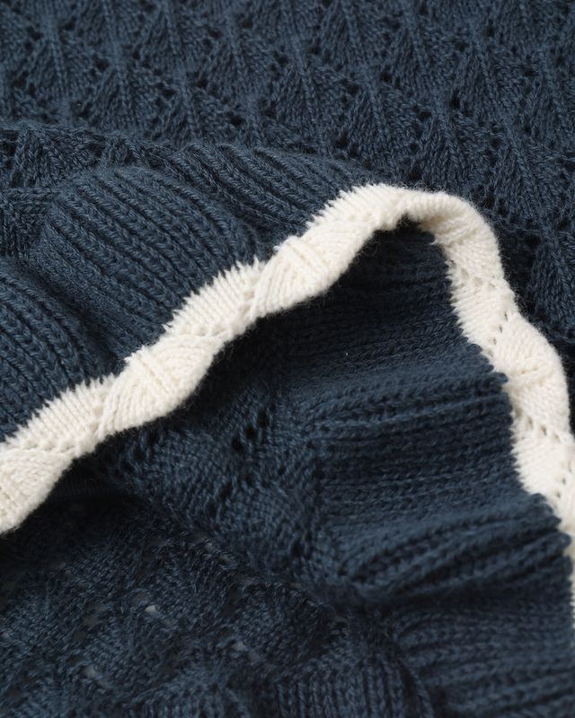 Close-up of a blue knitted fabric with white trim