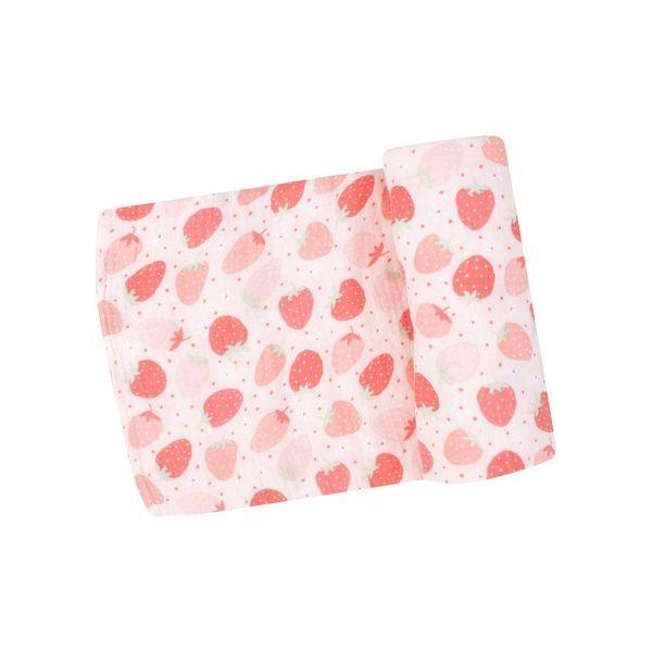baby swaddle with peach background with different color strawberries: red, light pink and pink strawberries on it. 