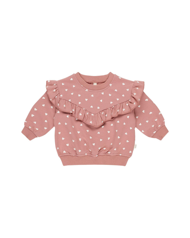 pink sweatshirt with ruffle across the chest with tiny white hearts all over the sweatshirt. 