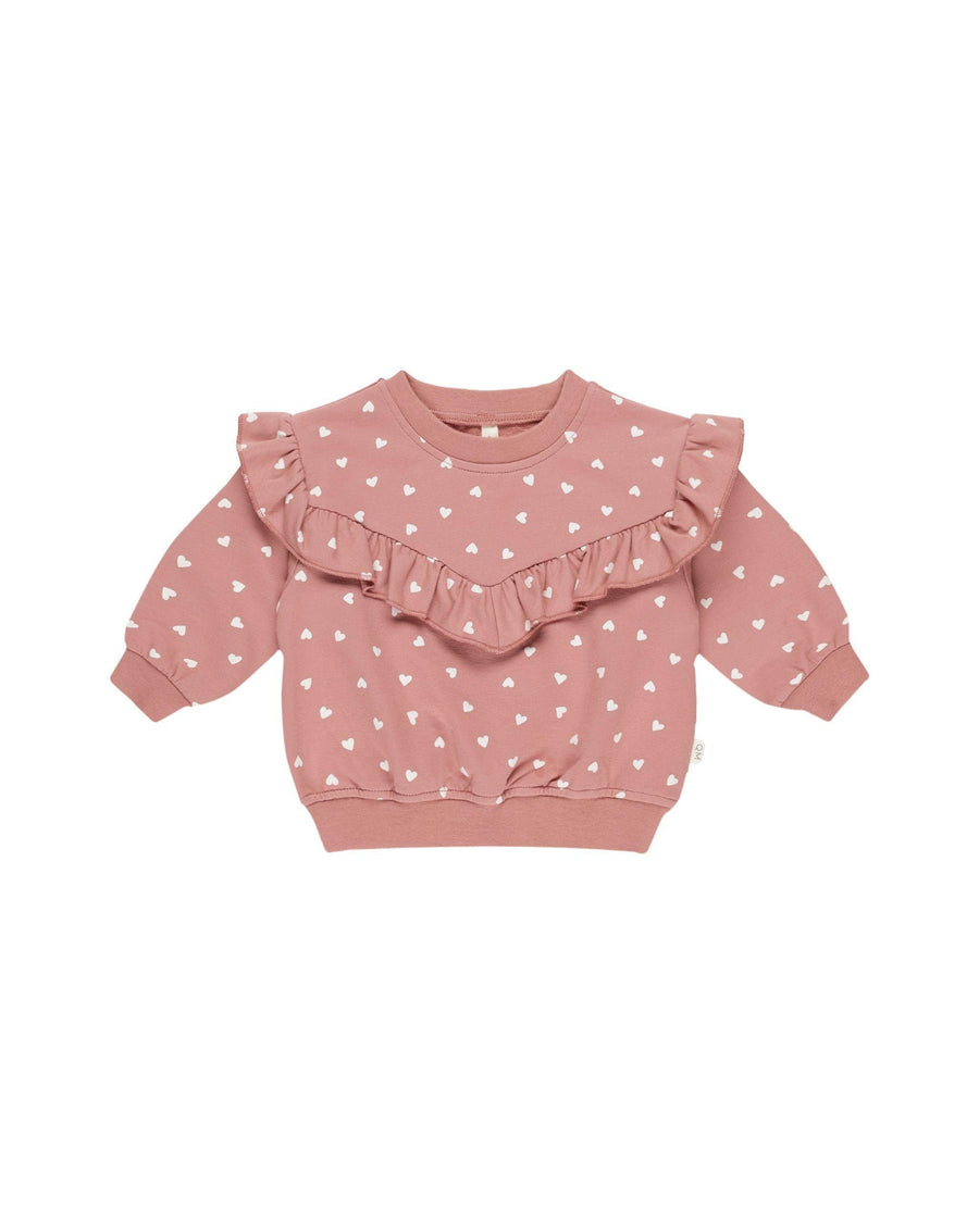 pink sweatshirt with ruffle across the chest with tiny white hearts all over the sweatshirt. 
