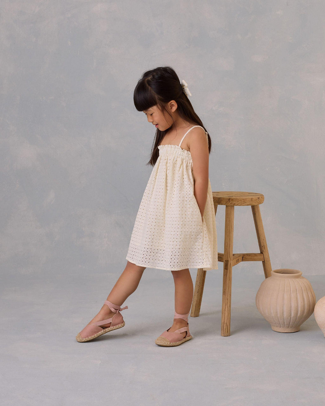 little girl modeling the ivory eyelet dress with spaghetti straps 