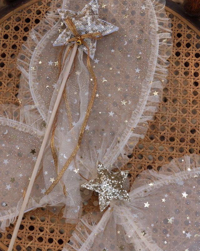 Decorative wand with star-shaped ends on a textured surface