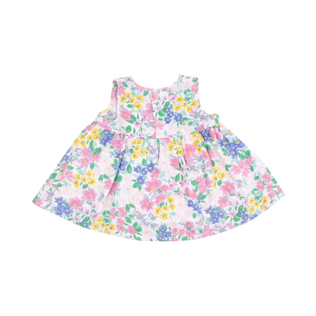 baby kimono style dress from the back with 3 buttons at the top of the dress. pink, yellow, and blue flowers printed all over the dress 