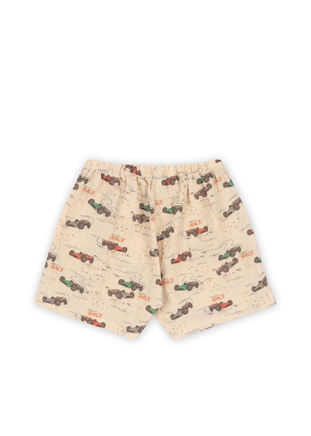 this is a picture of the back of the shorts with race car print all over the shorts. the colors of the cars are red, blue, green and the word 'race' is all over the shorts. 
