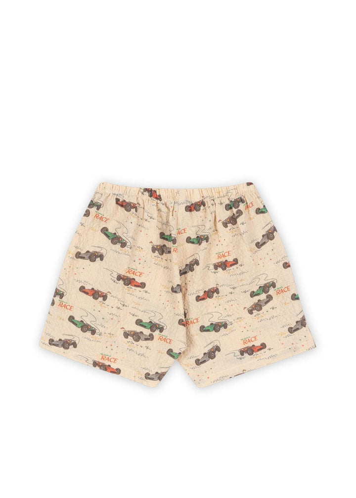 this is a picture of the back of the shorts with race car print all over the shorts. the colors of the cars are red, blue, green and the word 'race' is all over the shorts. 