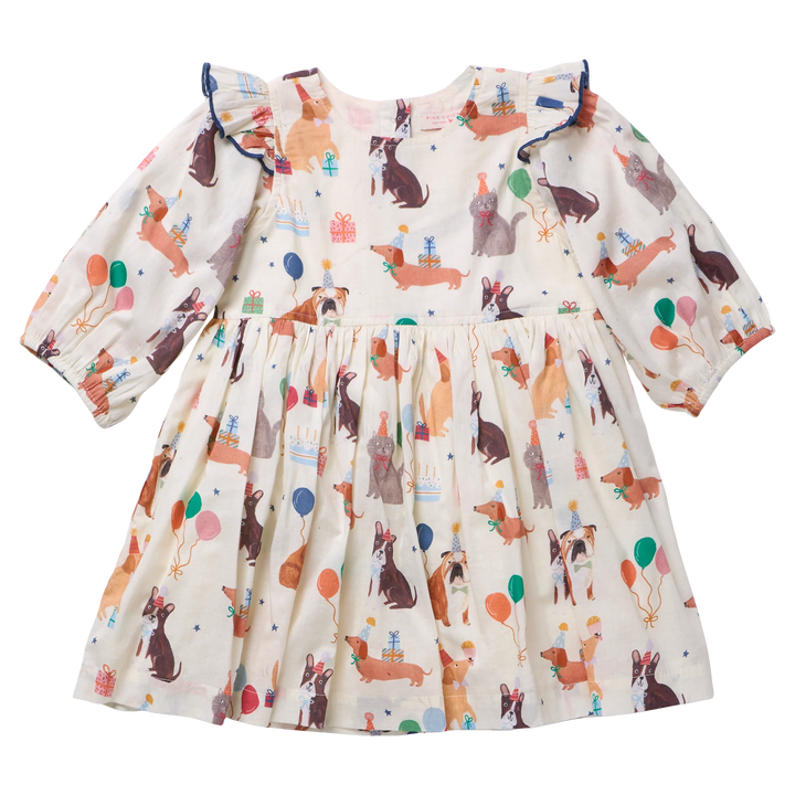 A baby girl's long-sleeve dress with a cream-colored base and an all-over print of dogs, cats and gifts, accented with blue ruffle trim at the shoulders.