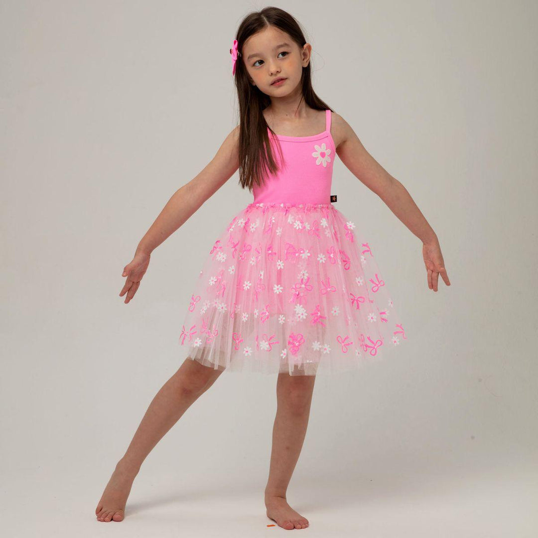 young girl modeling the hotpink tutu dress with daisy and bow appliques. you can see how full the skirt is in this picture