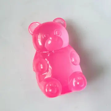 Pink gummy bear-shaped object on a white background