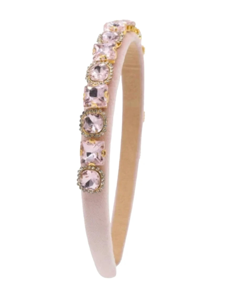 A pale pink velvet headband featuring a row of pink rhinestone-set bezel links, shown on a plain white background.