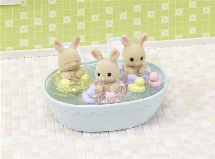 this picture shows the bunnies in the bath tub with rubber duckies. 