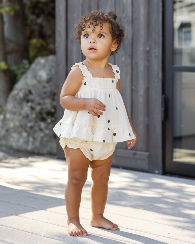baby wearing a polka dot two piece set with smocking on the top