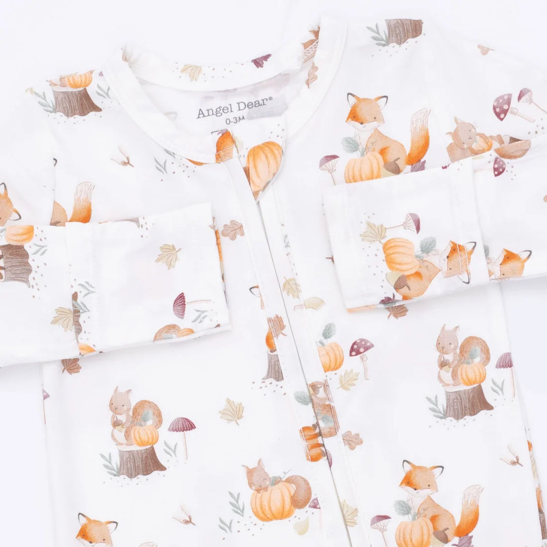 A baby long-sleeve footie with a white background and a cute autumn forest print featuring foxes, squirrels, pumpkins, and leaves. The brand name 'Angel Dreams' is visible on the inner neck label.