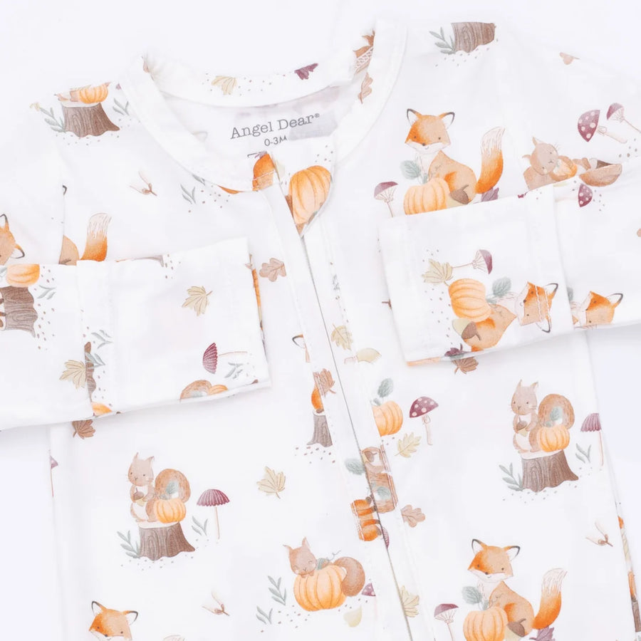 A baby long-sleeve footie with a white background and a cute autumn forest print featuring foxes, squirrels, pumpkins, and leaves. The brand name 'Angel Dreams' is visible on the inner neck label.