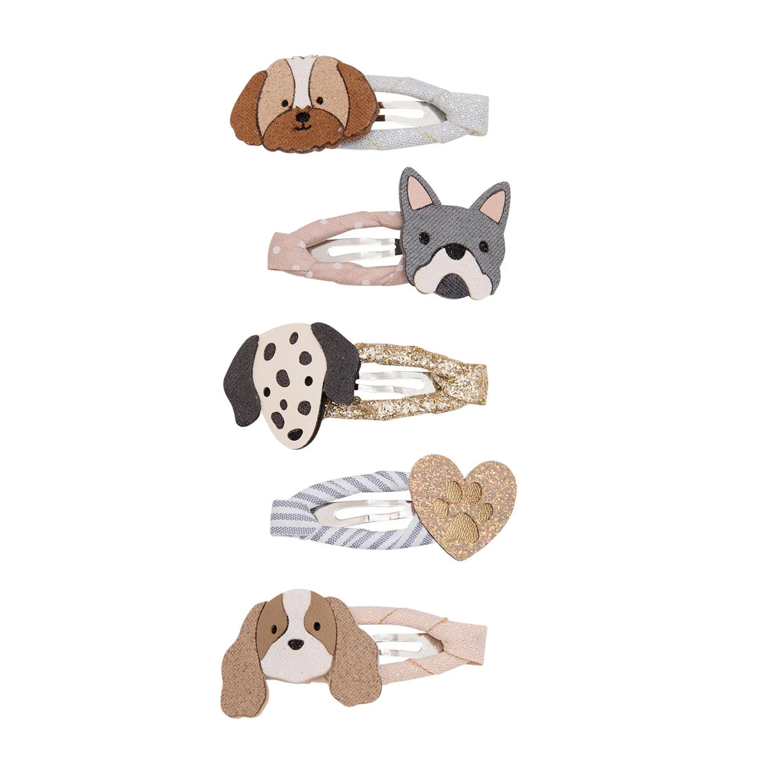 Five dog-themed hair clips arranged vertically on a white background, featuring different dog breeds and textures including brown and white, gray and white, black and white, striped gray and white, and a glittery gold heart.