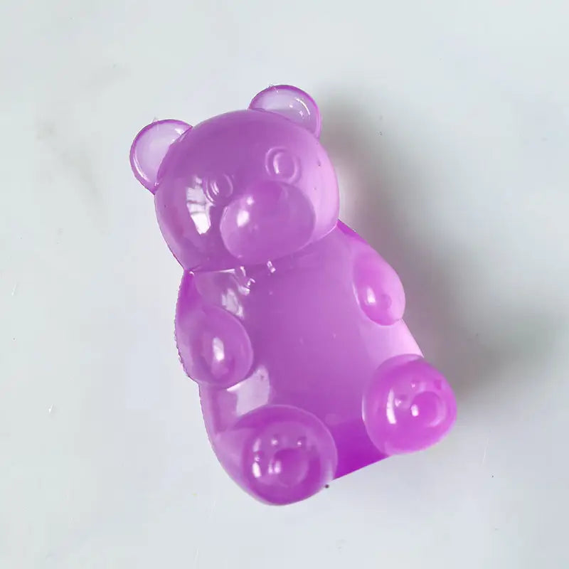 Purple gummy bear-shaped squished toy on a white background