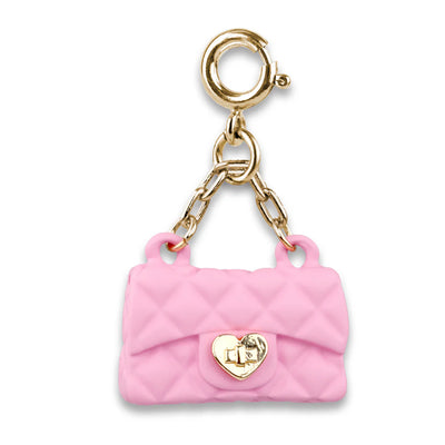 pink purse on a gold chain attached to a gold clasp