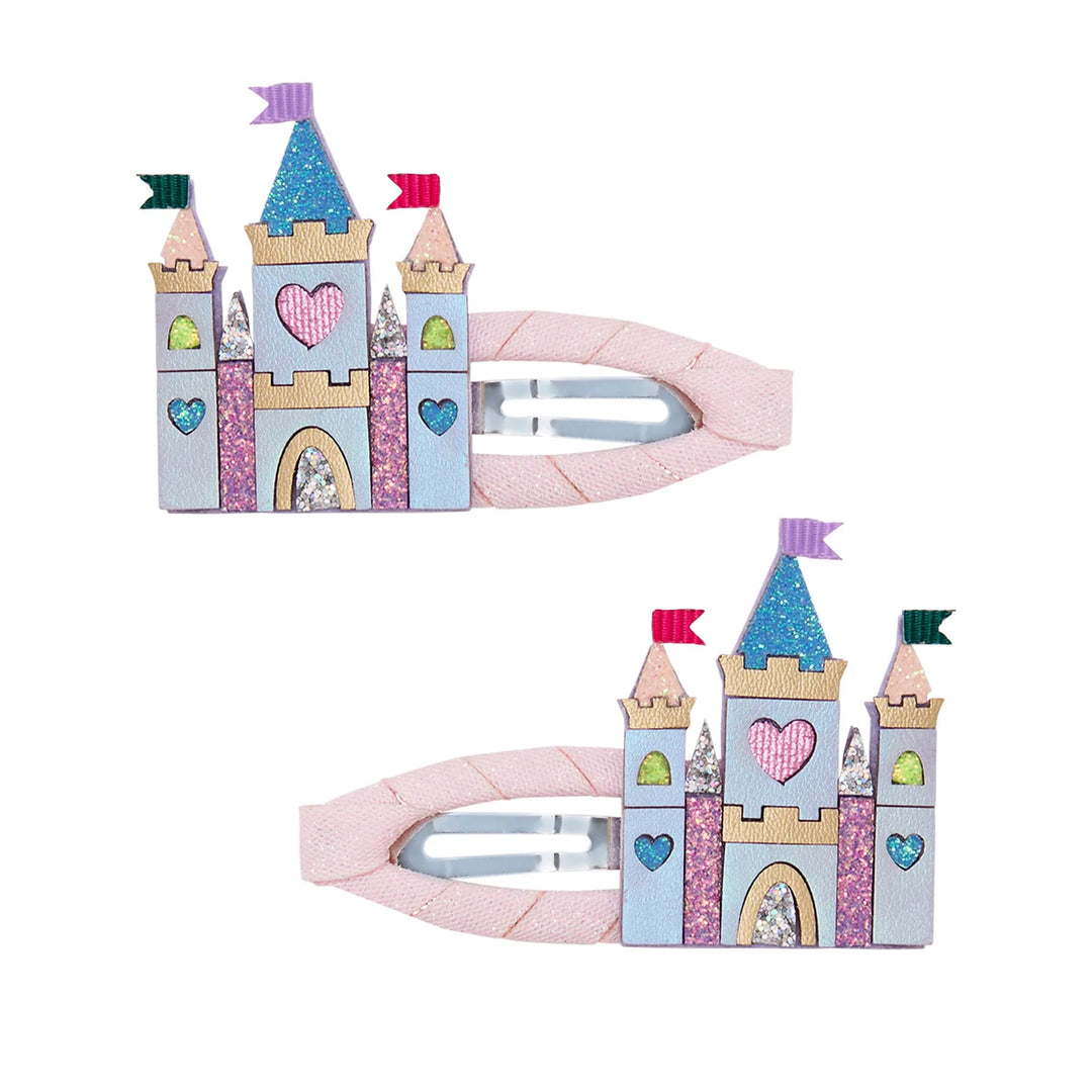 Two pink hair clips designed like a castle, shown on a plain white background. The clips feature a pastel castle design with glittery details, hearts, and flags in pink, blue, purple, green, and gold.
