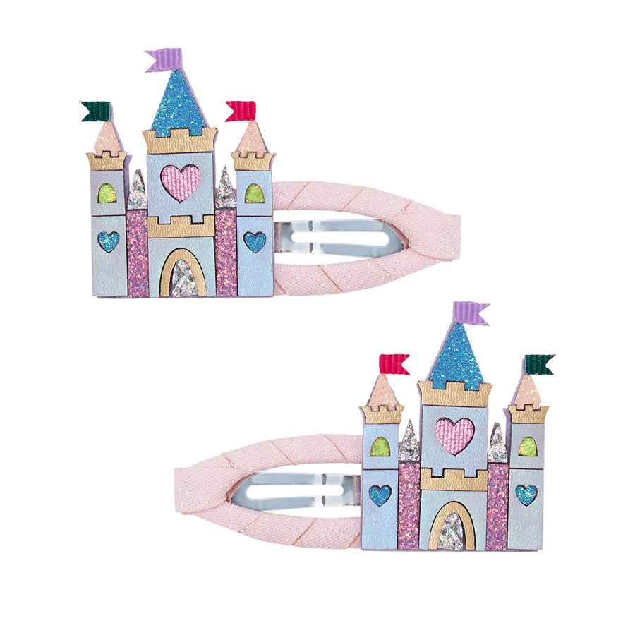 Two pink hair clips designed like a castle, shown on a plain white background. The clips feature a pastel castle design with glittery details, hearts, and flags in pink, blue, purple, green, and gold.