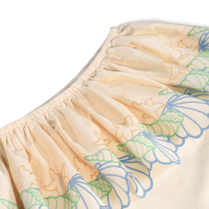 Beige shorts with colorful butterfly pattern on a white background
